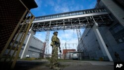 FILE - A Russian serviceman guards an area of the Zaporizhzhia Nuclear Power Station in territory under Russian military control, southeastern Ukraine, May 1, 2022.