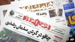 The front pages of the Aug. 13 edition of the Iranian newspapers, Vatan-e Emrooz, front, with the headline 'Knife in the neck of Salman Rushdie,' and Hamshahri, rear, with the headline: 'Attack on writer of Satanic Verses,' are pictured in Tehran Aug. 13,