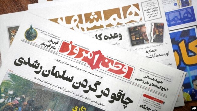The front pages of the Aug. 13 edition of the Iranian newspapers, Vatan-e Emrooz, front, with the headline 'Knife in the neck of Salman Rushdie,' and Hamshahri, rear, with the headline: 'Attack on writer of Satanic Verses,' are pictured in Tehran Aug. 13,