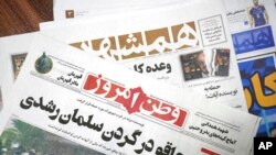 The front pages of the Aug. 13, 2022, edition of the Iranian newspapers, Vatan-e Emrooz, front, with the headline 'Knife in the neck of Salman Rushdie,' and Hamshahri, rear, with the headline: 'Attack on writer of Satanic Verses,' are pictured in Tehran.