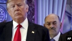 ARCHIVO - Allen Weisselberg, derecha, parado detrás del entonces presidente electo Donald Trump en una conferencia de prensa en el vestíbulo de la Trump Tower en Nueva York el 11 de enero del 2017. 