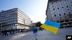 A boy runs with an Ukrainian flag during an event for Ukrainian Independence Day in Belgrade, Serbia, Aug. 24, 2022. The commemoration coincided with the six-month milestone of Russia's invasion of Ukraine.