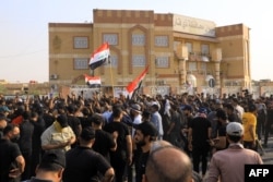 Supporters of Iraqi Shiite cleric Muqtada al-Sadr chant slogans as they gather outside the local government headquarters in the city of Nasiriyah in Iraq's southern Dhi Qar province, Aug. 29, 2022.