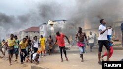 People run away during an anti-government protest in Freetown, Sierra Leone, August 10, 2022 in this picture obtained from social media.