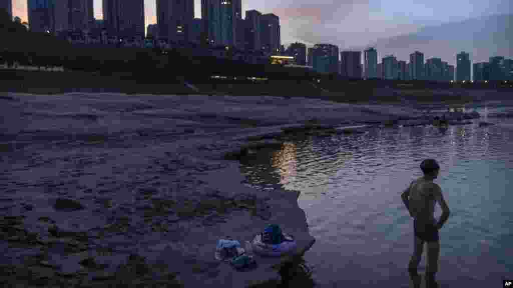 A man stands in water near the dry riverbed of the Yangtze River in southwestern China&#39;s Chongqing Municipality.