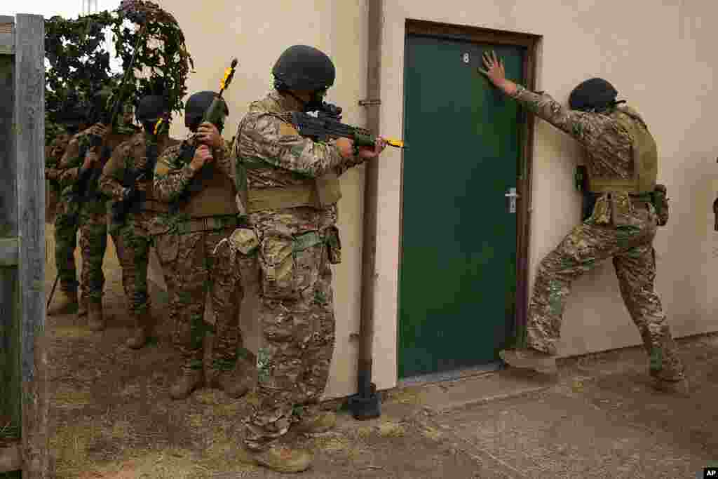 Ukrainian volunteer military recruits take part in an urban battle exercise while being trained by British Armed Forces at a military base in Southern England. (AP Photo/Frank Augstein)