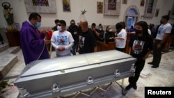 FILE - Relatives of photojournalist Margarito Martinez, 49, who was killed outside his home by unknown assailants, listen to a priest after his funeral Mass in Tijuana, Mexico, Jan. 21, 2022.