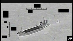 This photo released by the US Navy shows the Iranian Revolutionary Guard ship 'Shahid Bazair', left, towing a US Navy Saildrone Explorer in the Persian Gulf on Aug. 30, 2022. 