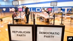 FILE - A voter checks in at Suffield Middle School on primary election day, August 9, 2022, in Suffield, Conn. 