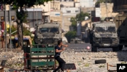 Palestinian demonstrators clash with the Israeli army while forces carry out an operation in the West Bank town of Nablus, Aug. 9, 2022.