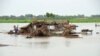 FILE - Villagers search for their belongings after their huts were destroyed in flood waters in Jaffarabad district of Balochistan province, Pakistan, Aug. 22, 2022.