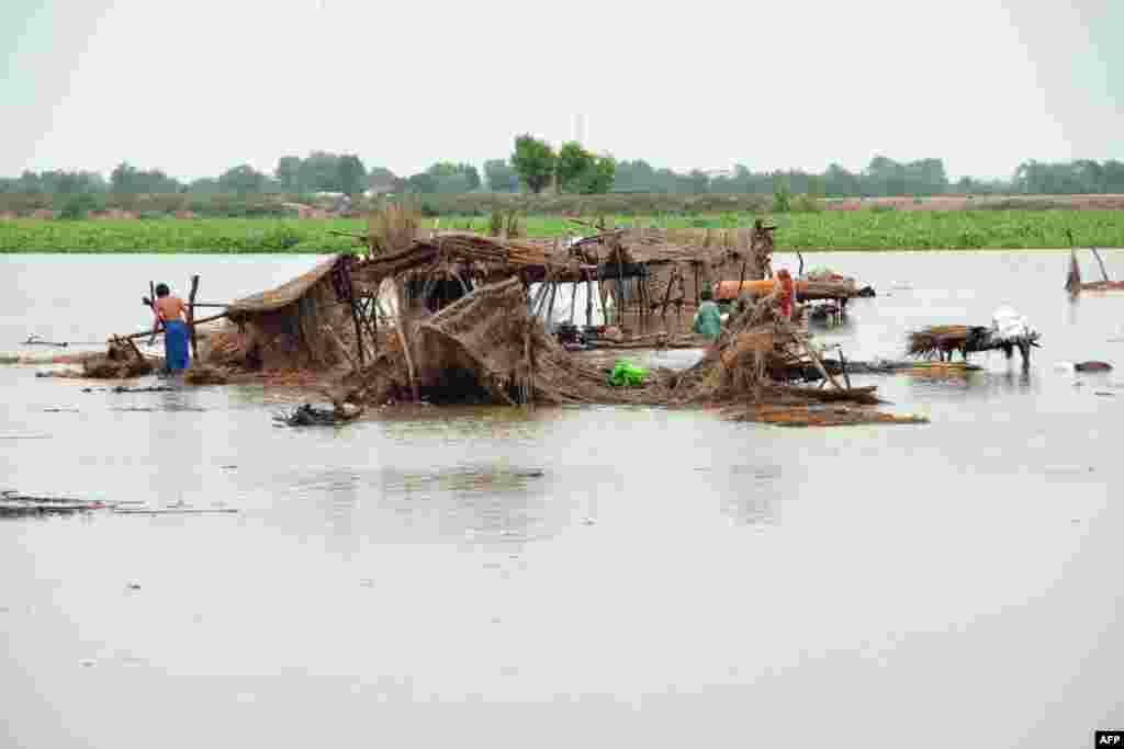 Villagers search for their belongings after their huts were destroyed in flood waters in Jaffarabad district of Balochistan province, Pakistan. (Photo by Fida HUSSAIN / AFP)