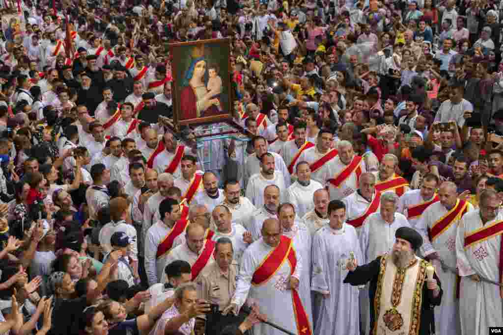 Religious leaders, including the monastery head Bishop Uannas, carry a painting of the Virgin Mary and baby Jesus up the site’s main pathway. On August 20, 2022. (Hamada Elrasam/VOA)