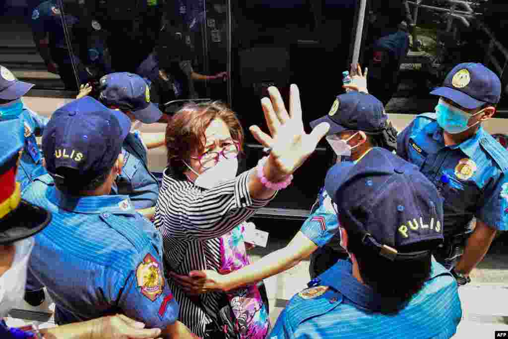 Former Philippine senator and human rights campaigner Leila de Lima, a high-profile critic of former president Rodrigo Duterte and his deadly drug war, is escorted by police as she emerges from her hearing at the Muntinlupa Trial Court in Manila.