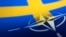 Bendera Swedia dan NATO terlihat dalam sebuah ilustrasi, 13 April 2022. (Foto: REUTERS/Dado Ruvic)