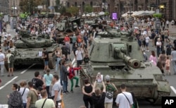 FILE - Ukrainians visit an avenue where captured Russian military vehicles are displayed in Kyiv, Ukraine, Aug. 20, 2022.