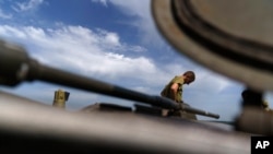 Un militar ucraniano se para sobre un tanque mientras toma un descanso durante el entrenamiento con su unidad en la región de Donetsk, este de Ucrania, el lunes 22 de agosto de 2022.