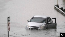 Sebuah mobil terjebak di tengah banjir yang menutupi jalan bebas hambatan di Dallas, Texas, pada 22 Agustus 2022. (Foto: AP/LM Otero)