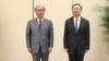 In this photo released by Xinhua News Agency, Yang Jiechi, right, a member of the Political Bureau of the Communist Party of China (CPC) Central Committee, poses for photos with Akiba Takeo, head of Japan's National Security Secretariat, in northern China, Aug. 17, 2022. 