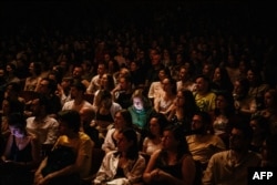 FILE - Spectators listen to poems of Ukrainian novelist and poet Serhiy Zhadan in the House of Cinema in Kyiv, amid Russia's invasion of Ukraine, Aug. 13, 2022.