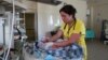 FILE - A medical worker takes care of a newborn baby who couldn't be evacuated to a bomb shelter, in a hospital damaged during shelling in Donetsk, in eastern Ukraine, June 14, 2022. 