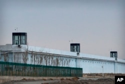 FILE - A person stands in a tower on the perimeter of the Number 3 Detention Center in Dabancheng in western China's Xinjiang Uyghur Autonomous Region on April 23, 2021. (AP Photo/Mark Schiefelbein)