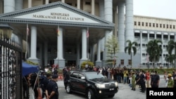 FILE - Former Malaysian Prime Minister Najib Razak leaves in a vehicle from Kuala Lumpur Court Complex after his second trial proceeding related to the 1Malaysia Development Berhad scandal, in Kuala Lumpur, Aug. 25, 2022. 