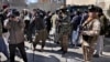 FILE - Afghan cameramen cover a protest against U.S. President Joe Biden in Kabul, Afghanistan, Feb. 15, 2022.