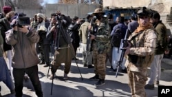 FILE - Afghan cameramen cover a protest against U.S. President Joe Biden in Kabul, Afghanistan, Feb. 15, 2022.