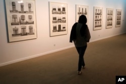 A visitor looks at artworks by German artists Bernd and Hilla Becher while visiting a 19th and 20th-century American and European minimalist and conceptual masterpieces show at the Tehran Museum of Contemporary Art in Tehran, Iran, Aug. 2, 2022.