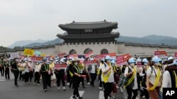 Pengikut Gereja Unifikasi memegang spanduk dalam aksi unjuk rasa di pusat kota Seoul, Korea Selatan, Kamis, 18 Agustus 2022, memprotes liputan media Jepang yang negatif tentang agama mereka. (AP/Lee Jin-man)