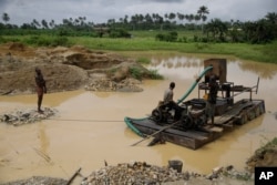 Men take a break at an illegal mining site in Osogbo, Nigeria, on May 31, 2022.