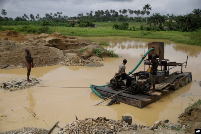 Men take a break at an illegal mining site in Osogbo, Nigeria, on May 31, 2022.