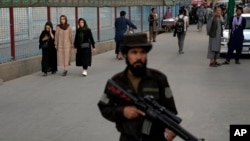 A Taliban fighter stands guard in the Shiite neighborhood of Dasht-e-Barchi, in Kabul, Afghanistan, Aug. 7, 2022.