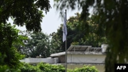 FILE - A Taliban flag hovers over the Afghan Embassy in Pakistan's capital, Islamabad, on Aug. 22, 2022. The Taliban hoisted their white flag at the embassy for the first time on August 19, replacing the previous government's flag.