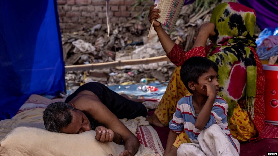 Sebuah keluarga pengungsi Rohingya beristirahat di tempat penampungan sementara setelah kebakaran menghancurkan kamp pengungsi Rohingya, New Delhi, India, 14 Juni 2021. (REUTERS/Danish Siddiqui)