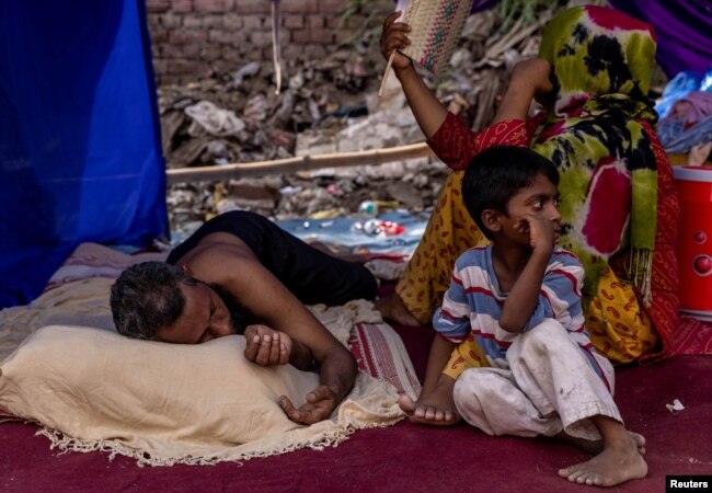 FILE - A Rohingya refugee family rests in a temporary shelter after a fire destroyed a Rohingya refugee camp on Saturday night, in New Delhi, India, June 14, 2021. (REUTERS/Danish Siddiqui)