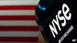 FILE - Sebuah tanda NYSE di lantai di Bursa Saham New York, New York Stock Exchange, New York, 15 Juni 2022.