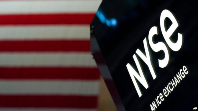 FILE - An NYSE sign is seen on the floor at the New York Stock Exchange in New York, June 15, 2022.