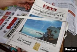 北京街头报摊上的报纸头版展示中国空军参加在台湾周边海空领域进行军演的照片。（2022年8月8日）