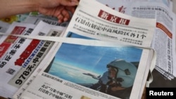 A view shows an image of an Air Force aircraft under the Eastern Theatre Command of China's People's Liberation Army (PLA) during military exercises in the waters around Taiwan, on a newspaper front-page, at a newsstand in Beijing, China August 8, 2022. REUTERS/Tingshu Wang