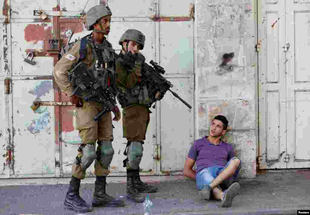 Israeli army soldiers detain a Palestinian during their clash with Palestinians, in Hebron in the Israeli-occupied West Bank.