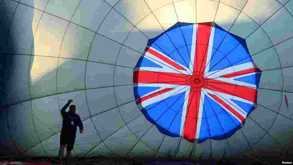 A crew member prepares a partly blown-up balloon at the yearly Bristol International Balloon Fiesta, near Bristol, Britain.