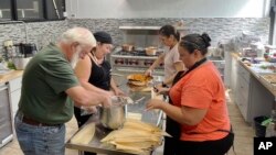 Volunteers at the American Indian Center of Chicago help chef Jessica Pamonicutt, second from left, prepare a contemporary Indigenous meal for seniors on Aug. 3, 2022. A fusion of Southwestern and Northern Indigenous ingredients, the spread includes turke