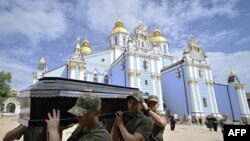 Ukrainian soldiers carry the coffin of late serviceman Roman Barvinok after a funeral service in St. Michael's Golden-Domed Cathedral in Kyiv, Aug. 28, 2022, amid the Russian invasion of Ukraine. 