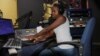 FILE - Radio Presenter Florence Mwale sits in the on-air studio at Capital FM in this undated photo. (Lameck Masina/VOA)