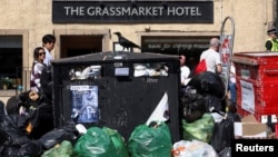 Waste overflows from bins on a street during a strike by waste services workers, in Edinburgh, Scotland, Aug. 27, 2022.