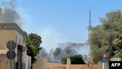 Smoke billows as rival Libyan groups exchange fire in the capital Tripoli, Aug. 27, 2022. 