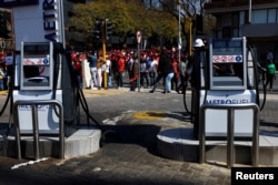 South Africans walk past a petrol station during a nationwide strike over the high cost of living, in Pretoria, South Africa, Aug. 24, 2022.