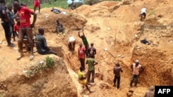 FILE - In this photograph taken on Apr. 4, 2018, gold miners work at a mining site in the Cameroon town of Betare Oya.